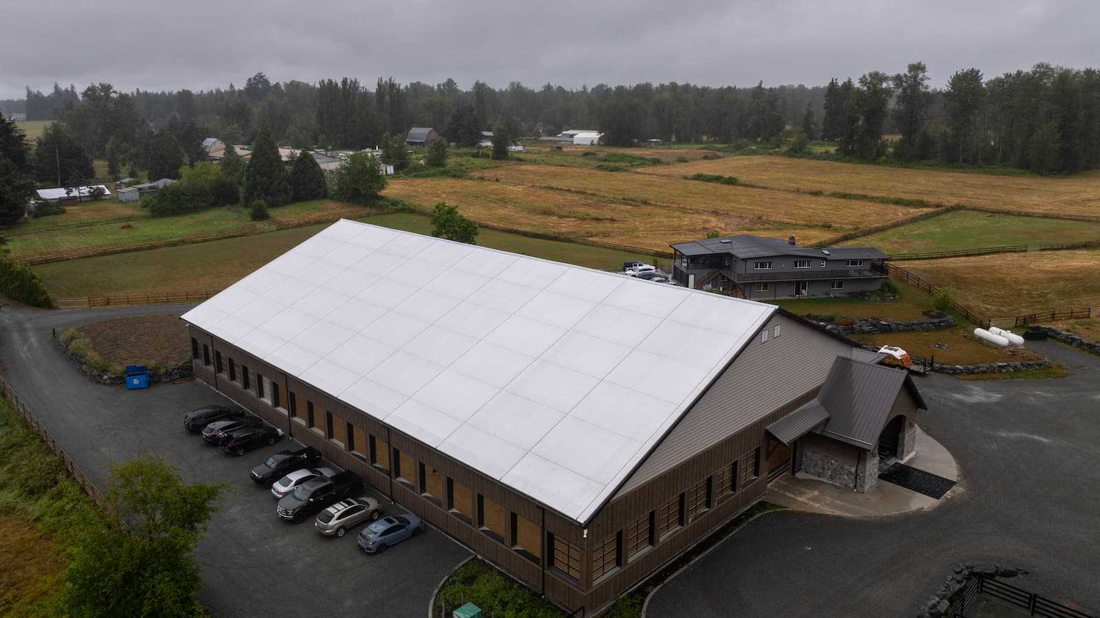 Exterior of a 106' x 180' fabric roof riding arena.